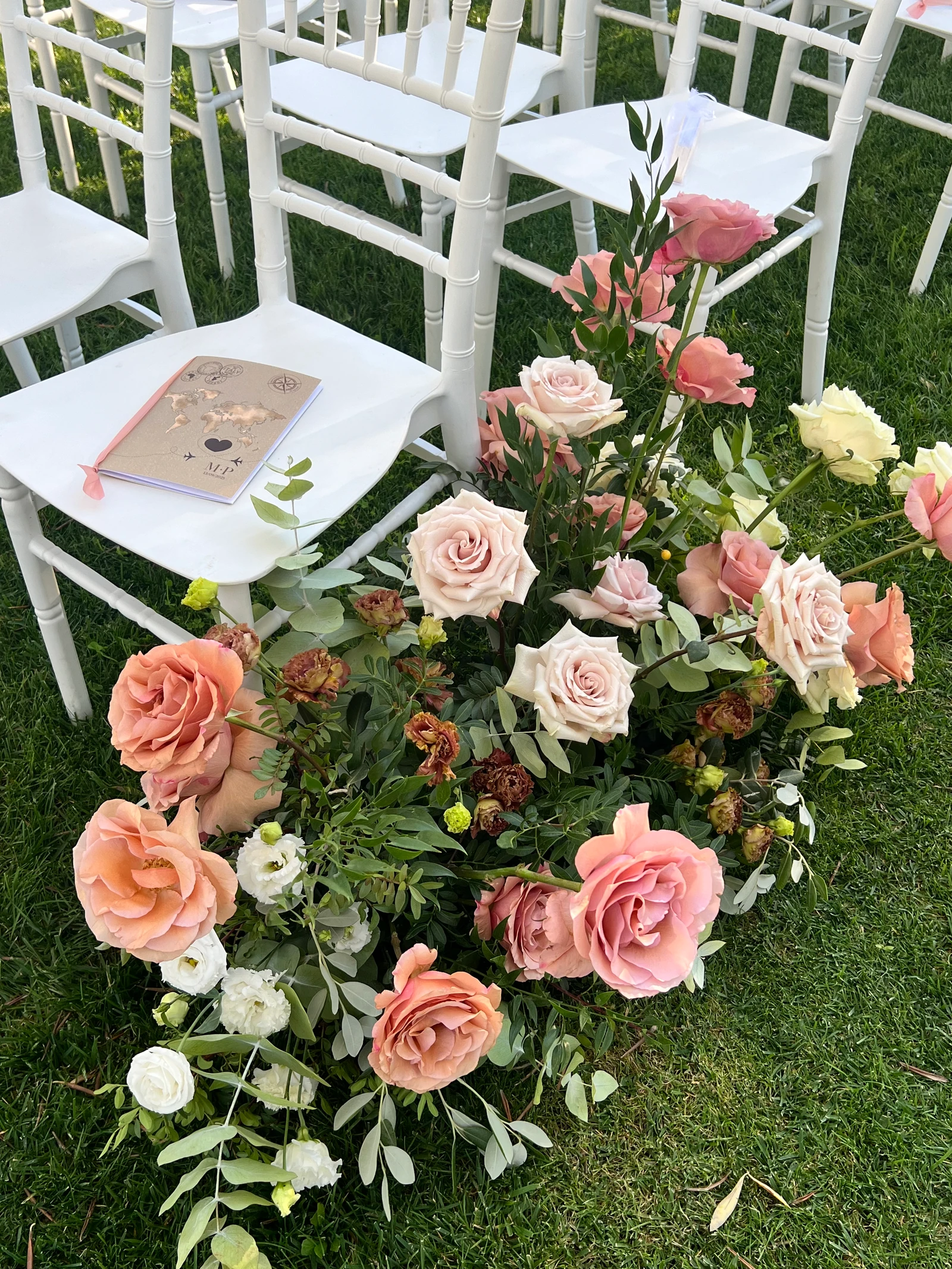 Rose cipria e pesca ai piedi delle sedie della cerimonia