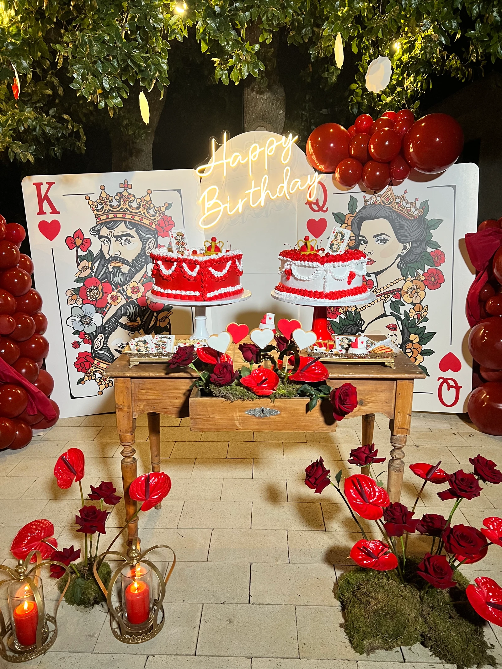 Allestimento di compleanno a tema carte da gioco, con torte e rose rosse